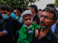 Shiite people are wearing Palestine flag stickers on their clothes while Muslims are chanting religious slogans as they take part in an Ashu...