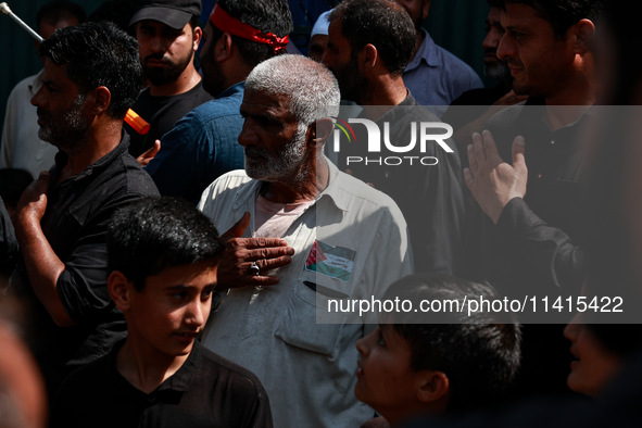 Shiite people are wearing Palestine flag stickers on their clothes while Muslims are chanting religious slogans as they take part in an Ashu...