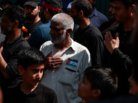 Shiite people are wearing Palestine flag stickers on their clothes while Muslims are chanting religious slogans as they take part in an Ashu...