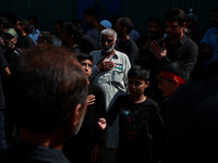 Shiite people are wearing Palestine flag stickers on their clothes while Muslims are chanting religious slogans as they take part in an Ashu...