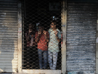 Street vendors are taking shelter inside a market as violence is erupting between police and anti-quota protestors in Dhaka, Bangladesh, on...