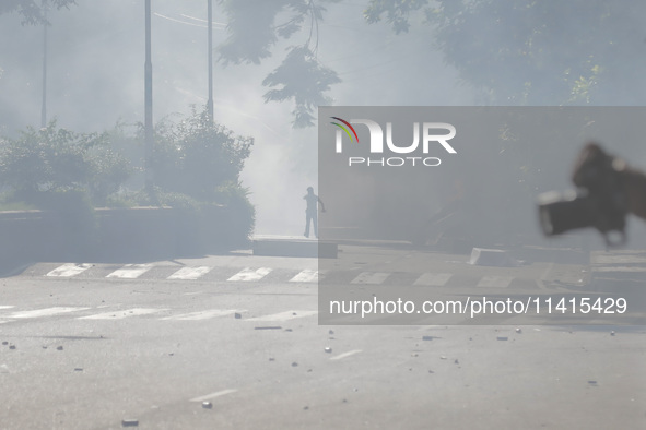 An anti-quota protestor is standing amidst the smoke of tear gas in Dhaka, Bangladesh, on July 17, 2024. 