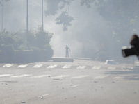 An anti-quota protestor is standing amidst the smoke of tear gas in Dhaka, Bangladesh, on July 17, 2024. (