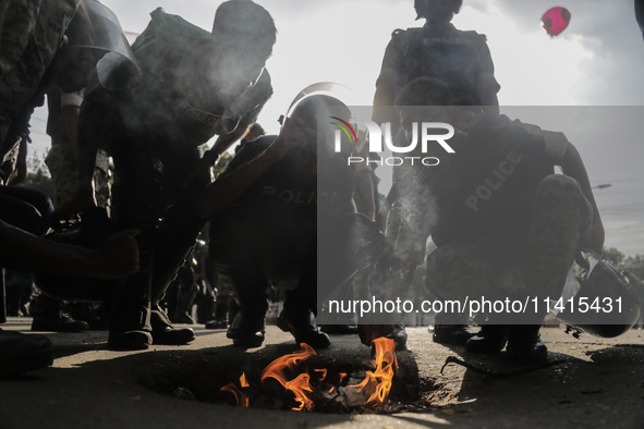 Police are trying to inhale fumes or burnt paper to dispel tear gas in Dhaka, Bangladesh, on July 17, 2024. 