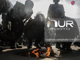 Police are trying to inhale fumes or burnt paper to dispel tear gas in Dhaka, Bangladesh, on July 17, 2024. (