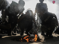 Police are trying to inhale fumes or burnt paper to dispel tear gas in Dhaka, Bangladesh, on July 17, 2024. (