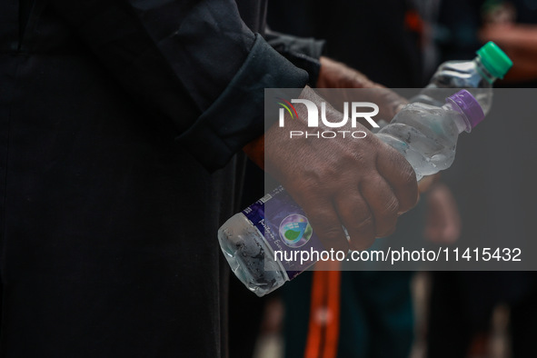 Shiite Muslims are keeping water bottles as they take part in the Ashura Procession on a hot day in Sopore, Jammu and Kashmir, India, on Jan...