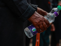 Shiite Muslims are keeping water bottles as they take part in the Ashura Procession on a hot day in Sopore, Jammu and Kashmir, India, on Jan...