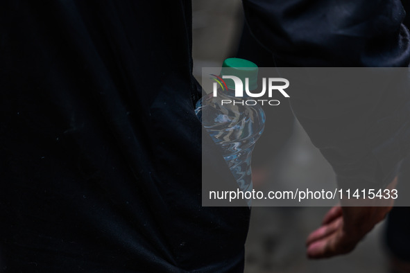 Shiite Muslims are keeping water bottles as they take part in the Ashura Procession on a hot day in Sopore, Jammu and Kashmir, India, on Jan...