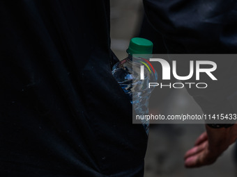 Shiite Muslims are keeping water bottles as they take part in the Ashura Procession on a hot day in Sopore, Jammu and Kashmir, India, on Jan...