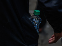 Shiite Muslims are keeping water bottles as they take part in the Ashura Procession on a hot day in Sopore, Jammu and Kashmir, India, on Jan...