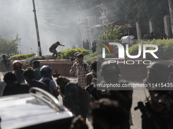 Anti-quota protestors are fleeing as police are firing tear gas and bullets towards them while approaching for a rally in Dhaka, Bangladesh,...