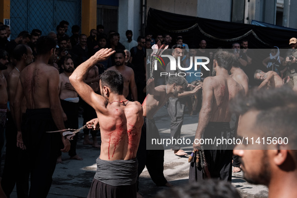 Shiite Muslims are flagellating themselves during a religious procession to mark Ashura in Pireaus, Greece, on July 17, 2024. The mourning o...