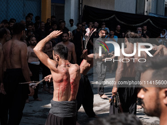 Shiite Muslims are flagellating themselves during a religious procession to mark Ashura in Pireaus, Greece, on July 17, 2024. The mourning o...