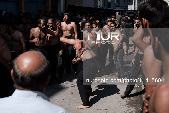 Shiite Muslims are flagellating themselves during a religious procession to mark Ashura in Pireaus, Greece, on July 17, 2024. The mourning o...