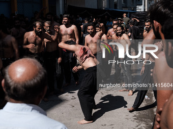 Shiite Muslims are flagellating themselves during a religious procession to mark Ashura in Pireaus, Greece, on July 17, 2024. The mourning o...