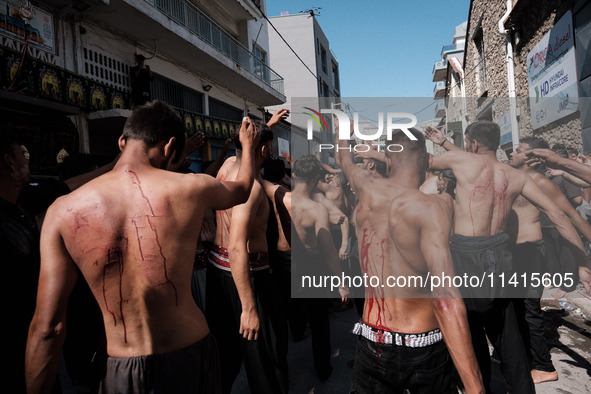 Shiite Muslims are flagellating themselves during a religious procession to mark Ashura in Pireaus, Greece, on July 17, 2024. The mourning o...