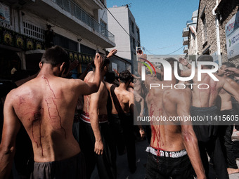 Shiite Muslims are flagellating themselves during a religious procession to mark Ashura in Pireaus, Greece, on July 17, 2024. The mourning o...