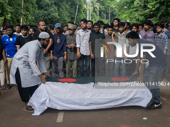 Anti-quota protesters are joining in a funeral prayer with a dummy coffin at the University of Dhaka, remembering those who are dying yester...