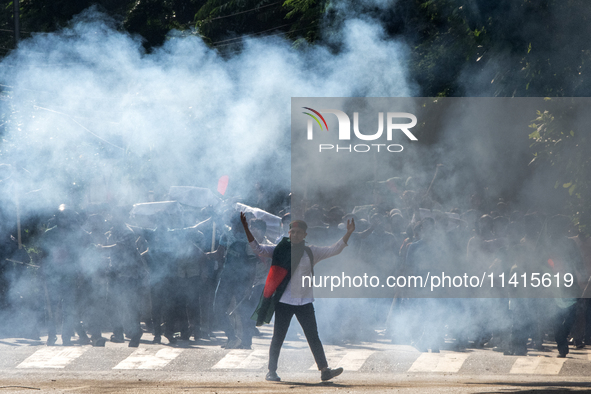 People are running as police are firing teargas during a coffin rally of anti-quota protesters at the University of Dhaka, a day after the c...