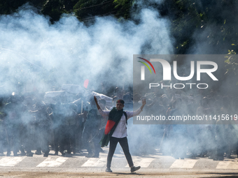 People are running as police are firing teargas during a coffin rally of anti-quota protesters at the University of Dhaka, a day after the c...