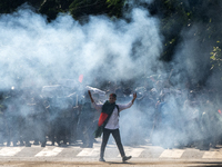 People are running as police are firing teargas during a coffin rally of anti-quota protesters at the University of Dhaka, a day after the c...