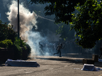 People are running as police are firing teargas during a coffin rally of anti-quota protesters at the University of Dhaka, a day after the c...