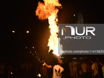 An Indian Muslim is blowing fire during the Muharram festival in Kolkata, India, on July 17, 2024. (