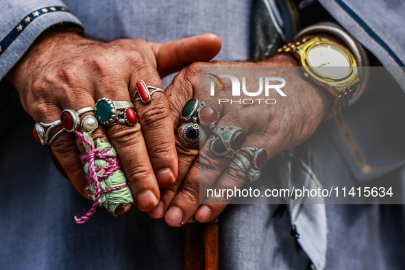 A Muslim man is wearing multiple gemstone rings while watching the Muharram procession in Sopore, Jammu and Kashmir, India, on July 17, 2024...