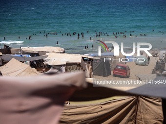 Displaced Palestinians are swimming next to a temporary camp in Deir el-Balah in the central Gaza Strip on July 17, 2024, amid the ongoing c...