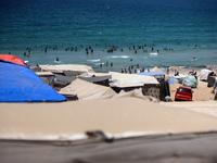 Displaced Palestinians are swimming next to a temporary camp in Deir el-Balah in the central Gaza Strip on July 17, 2024, amid the ongoing c...