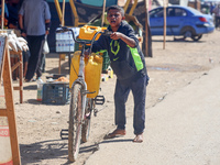 A boy is pushing a bicycle loaded with two jerrycans on the handlebars after filling up from a desalination plant in Deir el-Balah in the ce...