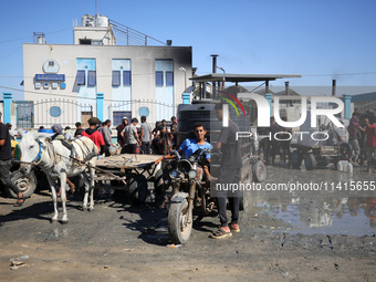 Palestinians are filling containers with water at a desalination plant in Deir el-Balah in the central Gaza Strip on July 17, 2024, amid the...