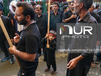 A Kashmiri Shia Muslim kid is participating in the Ashura procession in Srinagar, Indian Administered Kashmir, on July 17, 2024. (