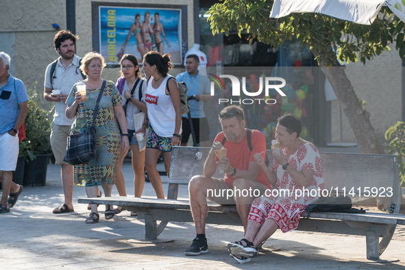 People are spending the afternoon in the city center at the gates of the first heat wave on the Iberian Peninsula, in Barcelona, Spain, on J...