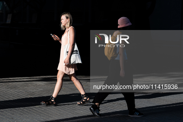 People are spending the afternoon in the city center at the gates of the first heat wave on the Iberian Peninsula, in Barcelona, Spain, on J...