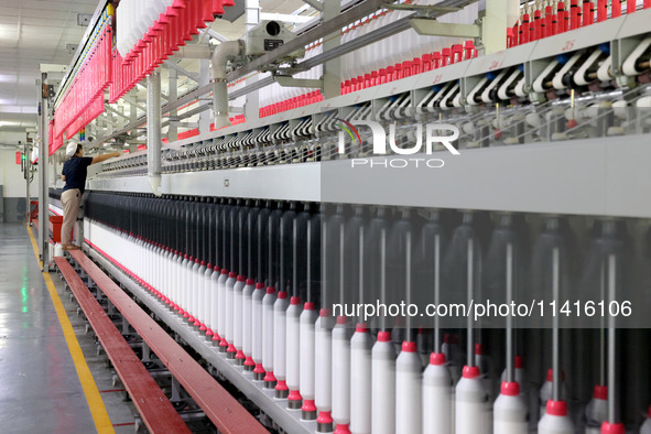 A worker is working on a textile production line in Fuzhou, China, on July 17, 2024. 