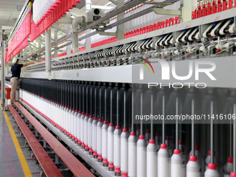 A worker is working on a textile production line in Fuzhou, China, on July 17, 2024. (