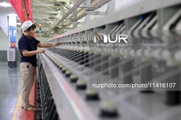 A worker is working on a textile production line in Fuzhou, China, on July 17, 2024. 