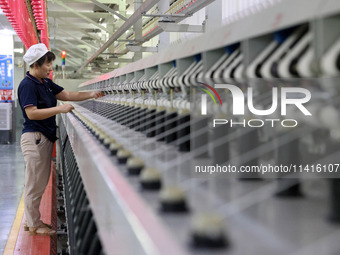 A worker is working on a textile production line in Fuzhou, China, on July 17, 2024. (