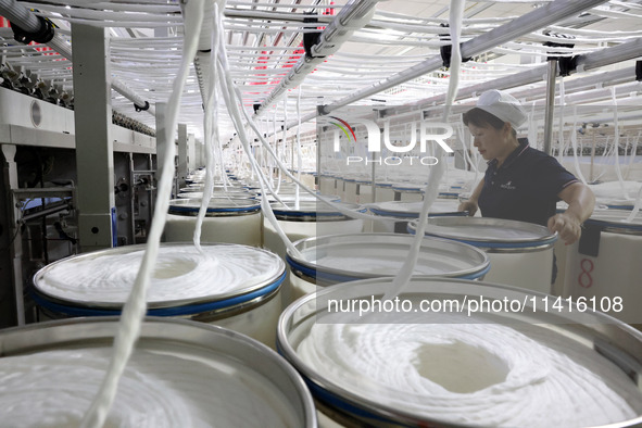 A worker is working on a textile production line in Fuzhou, China, on July 17, 2024. 