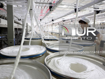 A worker is working on a textile production line in Fuzhou, China, on July 17, 2024. (