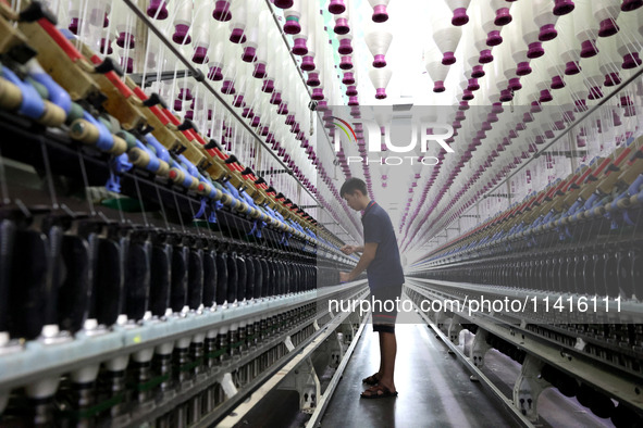 A worker is working on a textile production line in Fuzhou, China, on July 17, 2024. 