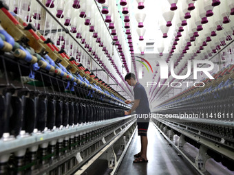 A worker is working on a textile production line in Fuzhou, China, on July 17, 2024. (