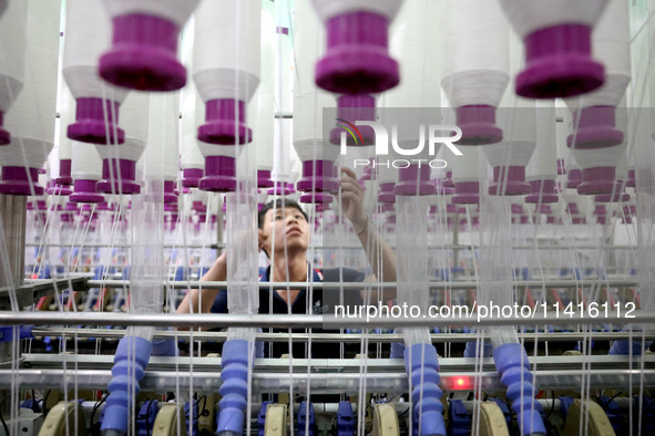 A worker is working on a textile production line in Fuzhou, China, on July 17, 2024. 