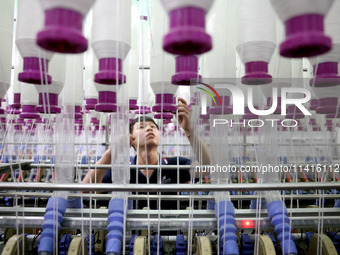 A worker is working on a textile production line in Fuzhou, China, on July 17, 2024. (