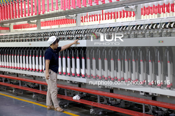 A worker is working on a textile production line in Fuzhou, China, on July 17, 2024. 