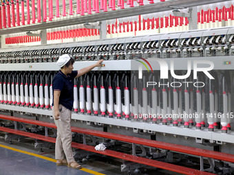 A worker is working on a textile production line in Fuzhou, China, on July 17, 2024. (