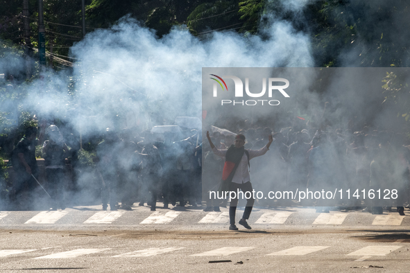 People are running as police are firing teargas during a coffin rally of anti-quota protesters at the University of Dhaka, in Dhaka, Banglad...