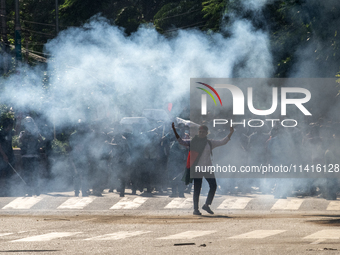 People are running as police are firing teargas during a coffin rally of anti-quota protesters at the University of Dhaka, in Dhaka, Banglad...